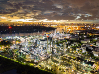 Fototapeta premium Aerial view of oil refinery near international port at night. Panorama of refinery plant at sunset. refinery factory and tank