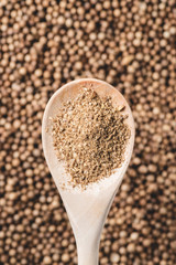 top view of wooden spoon with coriander powder and seeds
