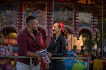 Obraz na płótnie Canvas couple in love standing in near carousel 