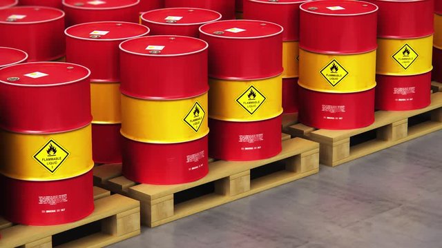Group of rows of red stacked oil drums in storage warehouse