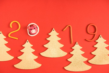 Fototapeta na wymiar top view of 2019 symbol, pig and fir trees on red