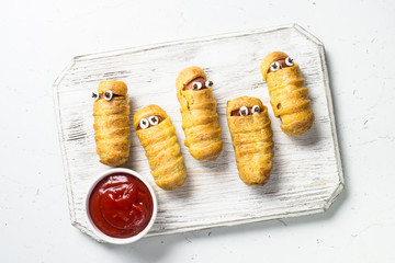 Halloween food. Scary sausage mummies in dough.