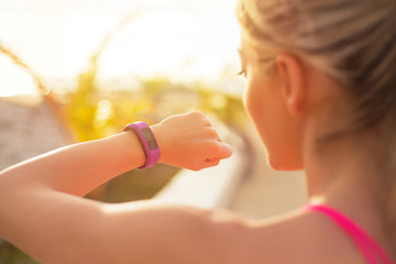 Fit girl using wearable tech during morning workout