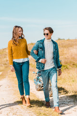 happy beautiful couple walking on rural meadow