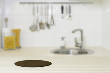 Wood table top with modern stone plate on blur kitchen background,can be used for display or montage your products or foods