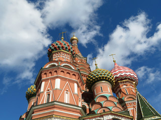 Fototapeta na wymiar St. Basil's Cathedral against the blue sky with white clouds. Russian architecture landmark, located on Red square in Moscow