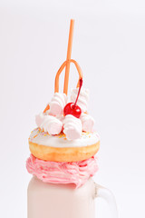 Pink strawberry freakshake with marshmallow and sweets.