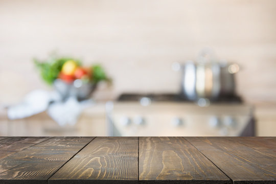 Blurred background. Modern kitchen with empty wooden tabletop and space for you.