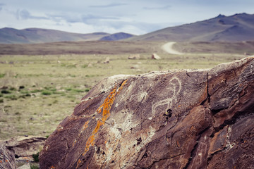 Tarkhatinsky megalithic complex fragment. Ancient petroglyphs. Altai Russia Toning sunrise