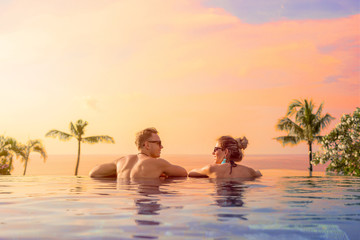 Happy couple on honeymoon in luxury hotel pool - obrazy, fototapety, plakaty