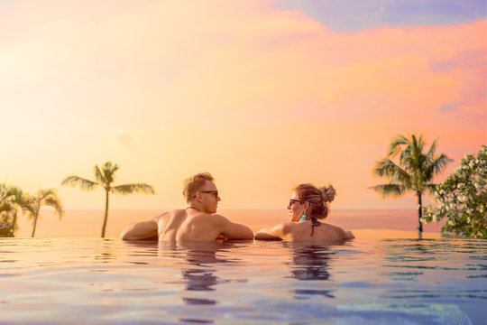 Happy couple on honeymoon in luxury hotel pool