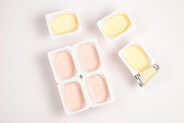 Plastic cup with tasty yogurt isolated on white. Top view. Space for text or design.