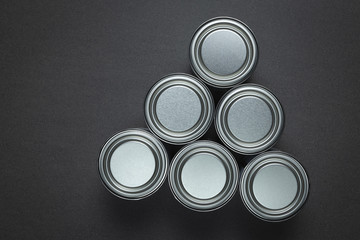 Metal paint tins with lids on granite background.