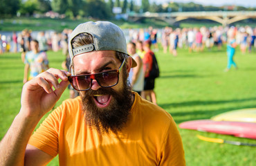 Man look through sunglasses sunny day outdoors. Urban event celebration. Hipster in cap visiting...