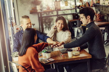 happiness successful teamwork hand together with cheerful and exited startup friends meeting together in cafe restaurant background