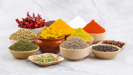 Indian Spices Collection Also Called Chili Powder, Turmeric Powder, Coriander, Fenugreek, Cumin, Mustard Seed, Salt, Black Pepper, Cardamom, Cloves, Turmeric Stick, Dry Chili on Vintage Background