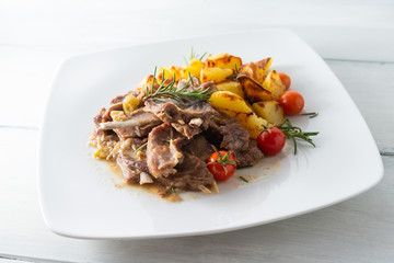Brasato di agnello con contorno di patate arrosto