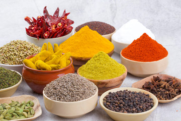 Indian Spices Collection Also Called Chili Powder, Turmeric Powder, Coriander, Fenugreek, Cumin, Mustard Seed, Salt, Black Pepper, Cardamom, Cloves, Turmeric Stick, Dry Chili on Vintage Background
