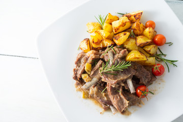 Brasato di agnello con contorno di patate arrosto