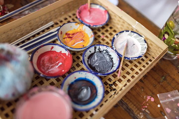 Watercolors are mixed in a palette.