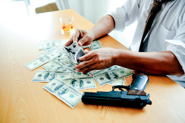 Businessmen with money in hand, US dollars, investment, success and profitable business ideas. Businessman with a firearm.