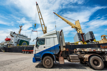 trailer truck lorry carry on and delivery cargo shipment from yard supply to the ship in port terminal, transportation meet together land and sea services being for logistics system to international.