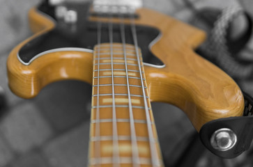Close up of electrical bass guitar fingerboard. Wooden bass with volume controller.