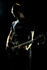 Young man plays guitar and sings. Portrait of a musician in black and white