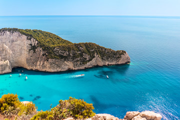 Shipwreck beach on Zakynthos island, Greece. Boat floating away and beautiful clouds on sky.