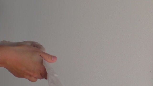 Female hands putting on clear plastic gloves.