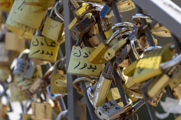 A lot of Golden locks hanging on the bars on the bridge