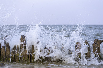 surf of the sea breaks on the rocks by the sea, foam and spray