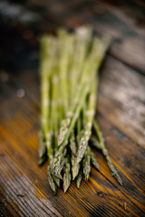 benches of fresh green asparagus on wooden background 