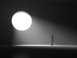 man stands near a light window in a dark room