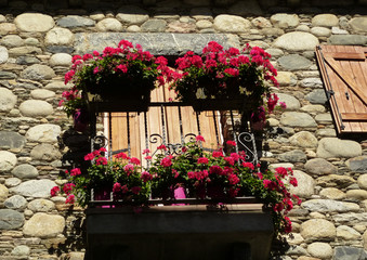 Fototapeta na wymiar detalle de balcón con flores en el pueblo antiguo de Benasque (Huesca). Pirineo aragonés