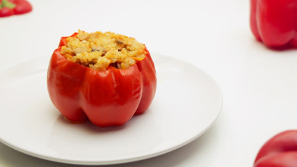 Bell peppers stufed with mushrooms, rice and cheese on a white plate on a white background