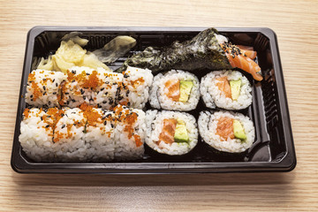 Japanese Cuisine: Tasty Uramaki , Futomaki and temaki served in the take-away box - selective focus