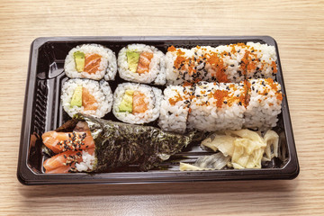 Japanese Cuisine: Tasty Uramaki , Futomaki and temaki served in the take-away box - selective focus