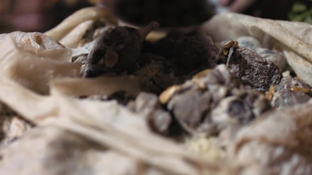 Mansaf. Close up, a chef peels back Markouk bread to reveal a dish of lamb cooked in yogurt and served on a bed of rice. Mansaf is the national dish of Jordan.