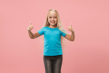 Happy teen girl standing, smiling isolated on trendy pink studio background. Beautiful female portrait. Young satisfy girl with sign ok. Human emotions, facial expression concept. Front view.