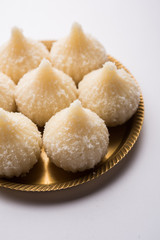 Sweet Modak made using coconut, khoya and sugar. Popular Maharashtrian recipe offered to lord Ganesha in Ganesh Festival. Served in a plate. Selective focus