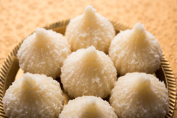 Sweet Modak made using coconut, khoya and sugar. Popular Maharashtrian recipe offered to lord Ganesha in Ganesh Festival. Served in a plate. Selective focus