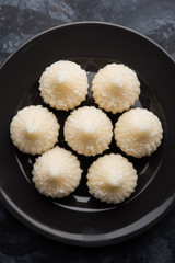 Sweet Modak made using coconut, khoya and sugar. Popular Maharashtrian recipe offered to lord Ganesha in Ganesh Festival. Served in a plate. Selective focus