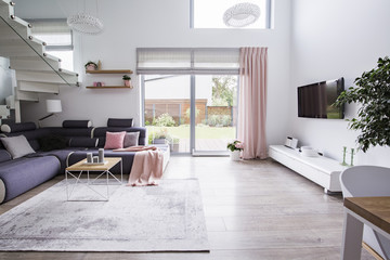 Real photo of a modern living room interior, terrace door and corner couch