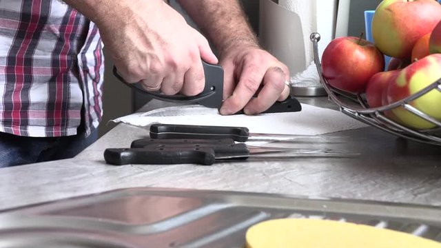 The man is sharpening a kitchen knife