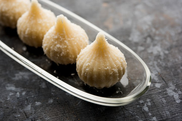 Sweet Modak made using coconut, khoya and sugar. Popular Maharashtrian recipe offered to lord Ganesha in Ganesh Festival. Served in a plate. Selective focus