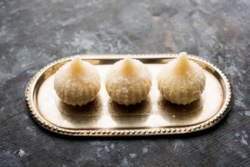 Sweet Modak made using coconut, khoya and sugar. Popular Maharashtrian recipe offered to lord Ganesha in Ganesh Festival. Served in a plate. Selective focus
