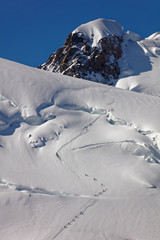 Pointe Lachenal, Chamonix, south-east France, Auvergne-Rh&ocirc;ne-Alpes. Climbers heading for Mont Blanc - scaling Pointe Lachenal's glacier crevasse with Mont Blanc du Tacul in background