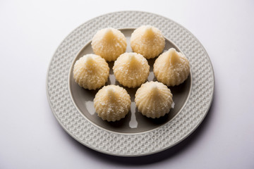 Sweet Modak made using coconut, khoya and sugar. Popular Maharashtrian recipe offered to lord Ganesha in Ganesh Festival. Served in a plate. Selective focus