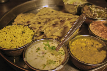 Closeup of colorful Thali set meal with a yellow rice, a dal and delicious sauces from Amritsar, India.